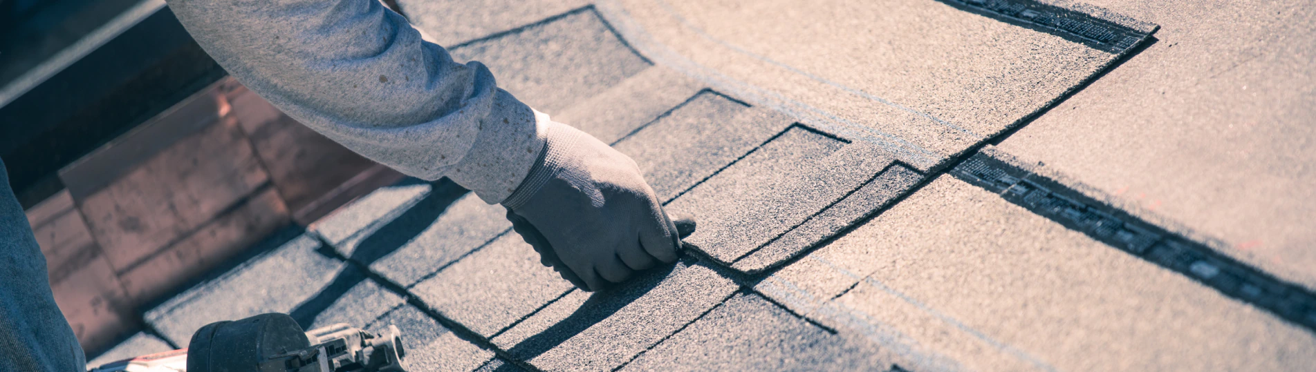 worker installing asphalt roof shingles